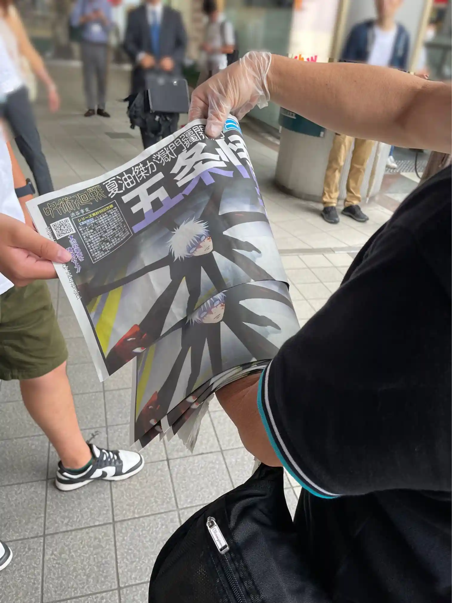 Jornal Noticiando o Selamento de Gojo é distribuído em Shibuya
